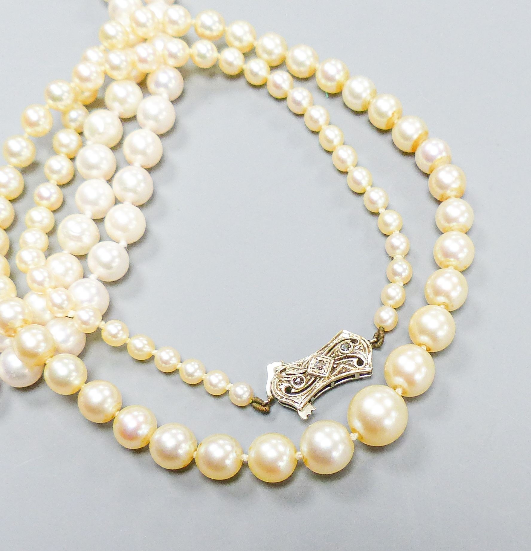 A single strand graduated cultured pearl necklace, with diamond set 9ct clasp, 43cm, a double strand cultured pearl choker necklace, with marcasite set clasp, 32cm and a pair of cultured pearl ear studs.